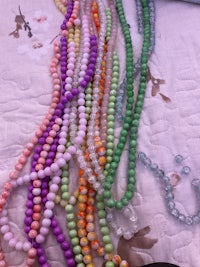 a bunch of colorful beads laying on a bed