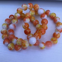 a bracelet with orange and white beads on it