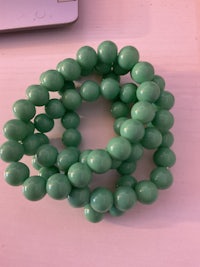 a green bead bracelet sitting on a table