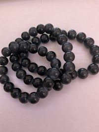 a group of black beads on a white surface