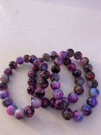 three purple and blue marbled bracelets on a table