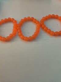 a group of orange beaded bracelets on a table