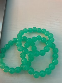 green beads on a table next to a laptop