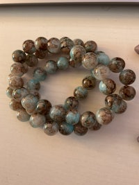 a blue and brown beaded bracelet hanging on a wall