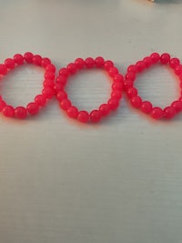 a group of pink bracelets laying on a table